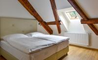 a bed in a room with wooden beams at Hotel Garden Court in Prague