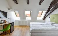 a bedroom with two beds and a desk with a television at Hotel Garden Court in Prague