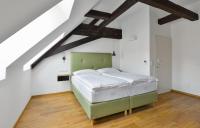 a bedroom with a green bed in a attic at Hotel Garden Court in Prague