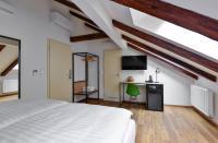 a bedroom with a white bed and a desk at Hotel Garden Court in Prague