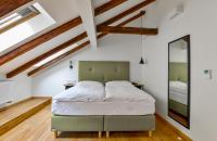 a bedroom with a green bed in a room with wooden ceilings at Hotel Garden Court in Prague