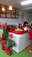 a woman standing at a counter in a fast food restaurant at Jia Mei Fa Homestay in Taitung City