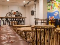 a room with tables and chairs and a bike on the wall at Khan Hotel in Kaohsiung