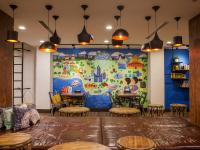 a room with tables and chairs and a large mural at Khan Hotel in Kaohsiung