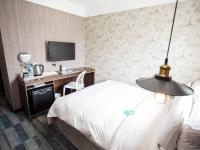 a hotel room with a bed and a desk at Khan Hotel in Kaohsiung