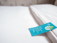 a blue tag sitting on a white bed at Khan Hotel in Kaohsiung