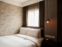 a bedroom with a bed with a price tag on it at Khan Hotel in Kaohsiung