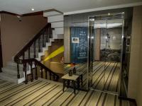 a lobby with a staircase with a glass elevator at Khan Hotel in Kaohsiung