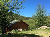 a small wooden building in a field with trees at Le Chalet in Prémian