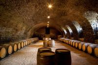 a wine cellar with barrels in a tunnel at Château de Pierreclos in Pierreclos