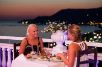 zwei Frauen, die an einem Tisch sitzen mit Teller Essen in der Unterkunft Sunny Hill Alya Hotel in Alanya