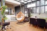 a room with a table and chairs and a swing at Antlers Guest House in Taitung City