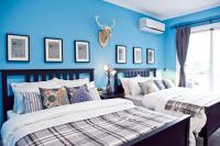 two beds in a room with blue walls at Antlers Guest House in Taitung City