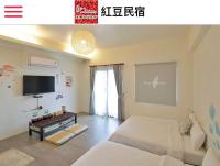 a bedroom with a bed and a flat screen tv at Redbean Guesthouse in Wujie