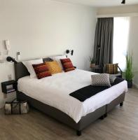 Un dormitorio con una cama grande con almohadas de colores. en CITYSTAY, en Amberes