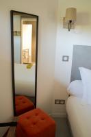 a bedroom with a mirror and a bed and a stool at Hôtel Le 23 in Sauternes