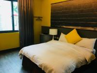 a bedroom with a large white bed with yellow walls at Great Nature Villa in Jiji