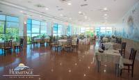 a dining room with tables and chairs and windows at Hermitage Hotel in Silvi Marina