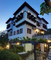 Un gran edificio con mesas y sillas delante. en Hotel Stoikos, en Vizítsa