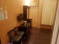 a room with a desk with two chairs and a television at Ming Yang B&amp;B in Fenqihu