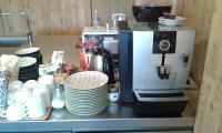 a coffee maker on a counter with plates and cups at Hotelski in Verbier