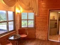 a room with two windows and a table and chairs at New Life Hot Spring Resort in Yuli