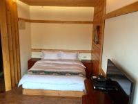 a small bedroom with a bed and a television at New Life Hot Spring Resort in Yuli