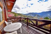 a wooden balcony with a table and a view of mountains at Beverly B&amp;B in Ren&#39;ai