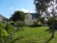 a house with a yard with palm trees at VILLA THEDIEBERT in Barneville-Carteret