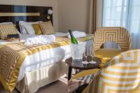 a hotel room with two beds and a table and chairs at Hotel Carlton in Beaulieu-sur-Mer