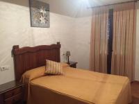 a bedroom with a bed with a wooden head board at El Corral de Dolores in El Bosque