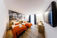 a bedroom with two beds and a flat screen tv at B-INN Lier in Lier