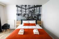 a bedroom with a large bed with orange pillows at B-INN Lier in Lier