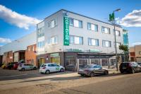 Un gran edificio con coches aparcados delante. en Hostal Campestre, en La Cistérniga