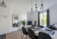 a dining room and living room with a table and chairs at Nice Apartment Garden - 5 min DISNEYLAND Paris - Val d&#39;Europe Center in Chessy