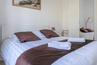 a large bed with two towels on top of it at Nice Apartment Garden - 5 min DISNEYLAND Paris - Val d&#39;Europe Center in Chessy