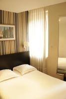 a bedroom with a white bed with a window at Grand Hôtel d&#39;Orléans in Toulouse