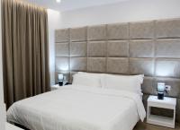 Un dormitorio con una cama grande con un cabecero grande. en Ramel Hotel, en Tirana