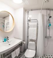 a bathroom with a sink and a toilet and a mirror at Hotel Sparre in Porvoo