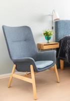 a blue chair sitting next to a bed at Hotel Sparre in Porvoo