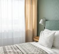 a bedroom with a bed with a window and a lamp at Hotel Sparre in Porvoo