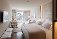 a bedroom with a large bed and a living room at Hotel Bellevue Dubrovnik in Dubrovnik