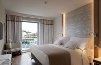 a bedroom with a large bed and a large window at Hotel Bellevue Dubrovnik in Dubrovnik