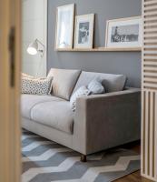 a gray couch in a living room with pictures on the wall at Hotel Bellevue Dubrovnik in Dubrovnik