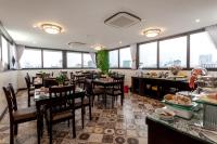 a restaurant with tables and chairs and large windows at Hotel De La Seine in Hanoi