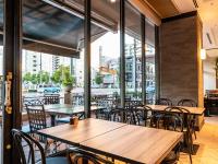 a restaurant with tables and chairs and a view of a city at HOTEL MYSTAYS Matsuyama in Matsuyama