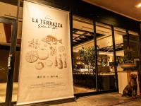 a dog sits in front of a banner outside a restaurant at HOTEL MYSTAYS Matsuyama in Matsuyama