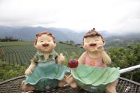 two dolls sitting on a table with an apple in their mouths at Alishan B&amp;B YunMinGi in Fenqihu