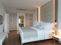 a bedroom with a large white bed and a living room at Hotel Bellevue Dubrovnik in Dubrovnik