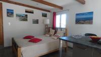 a bedroom with a bed with red pillows and a table at mini villa studio que du bonheur in Calenzana